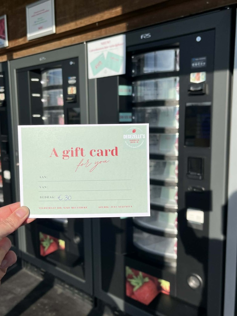 Een hand houdt een cadeaubon van Degezelle's Aardbeien Drive-In vast.